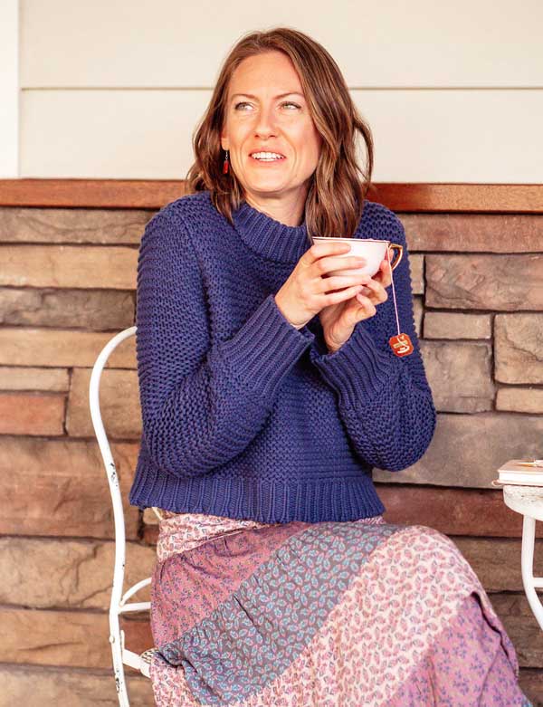 Samara, a Melbourne Doula sitting on the patio holding a cup of tea