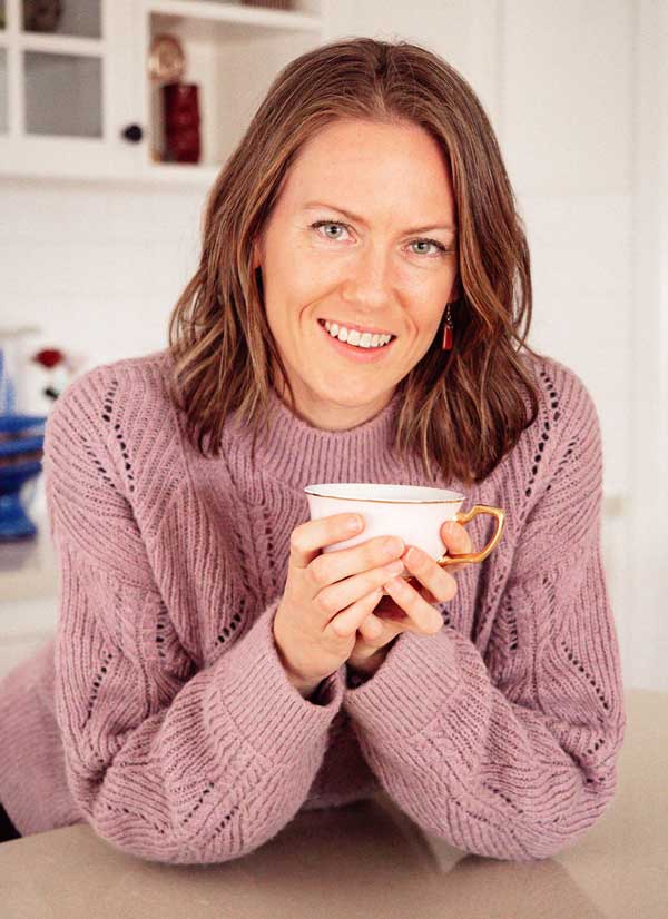 Samara, a Melbourne Doula sitting in the kitchen holding a cup of tea