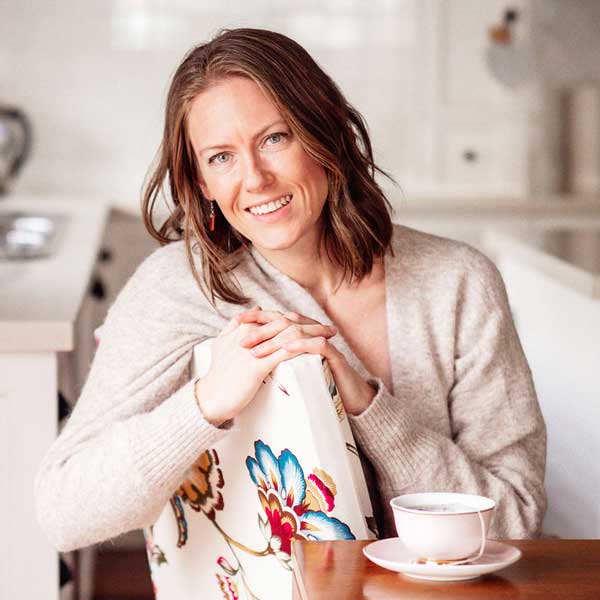 Samara, a Melbourne Doula sitting at the kitchen table with a cup of tea