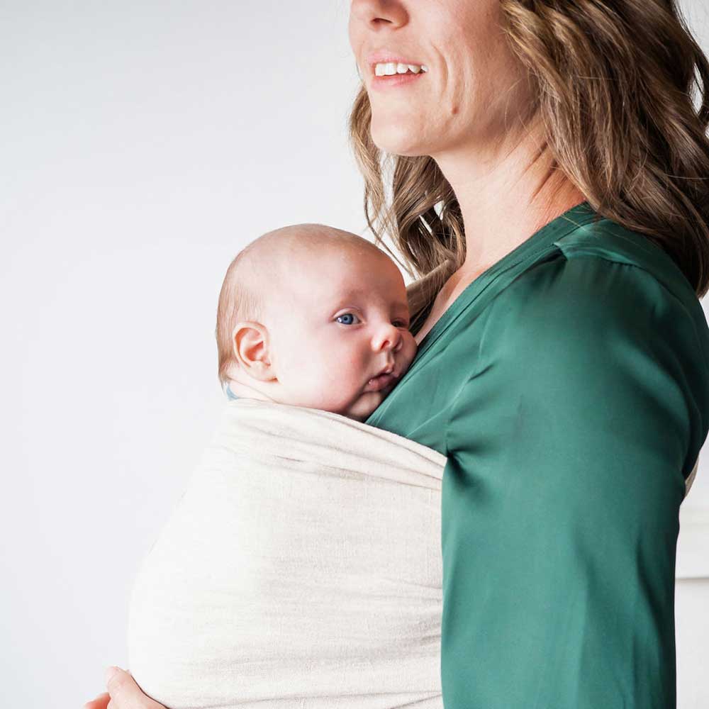 New Season Doula Care carrying a baby in a sling